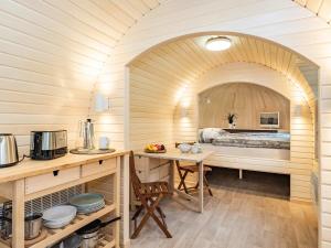 a kitchen with a table and a bed in a room at Tinyhouse 1 in Heringsdorf