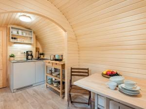 a kitchen with a table and a refrigerator and a stove at Tinyhouse 1 in Heringsdorf
