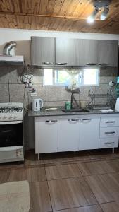 Una cocina con gabinetes blancos y una estufa. en Casa de campo Emmanuel, en Concepción del Uruguay 9 fotos más