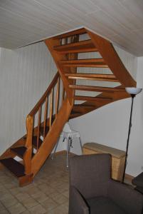 escalera de madera en la sala de estar con sofá en Ferienhaus Uferstraße, en Wittmund