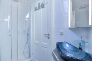 a bathroom with a blue sink and a shower at Abaco 4N in Wenningstedt +15 photos