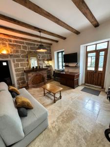 a living room with a couch and a piano at Casa Arena Authentique maison de village avec piscine au cœur de l’Alta Rocca - Zoza in Zoza