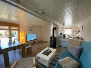 a living room with a blue couch and a table at Ferienhaus "kleine Auszeit" gern auch mit Hund in Stiege +12 photos