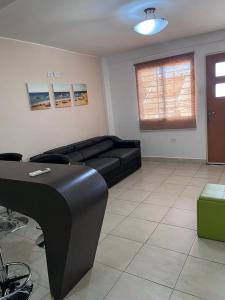 Una sala de estar con un sofá negro y una mesa. en Ciudad Flamingo, Morrocoy chichiriviche, tucacas 7, en Chichiriviche 12 fotos más