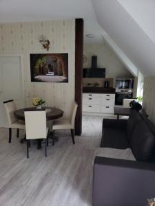 a living room with a table and a kitchen at SECRA Exclusive Ferienwohnung Schlaubetal Müllrose 1 - Seenähe in Müllrose