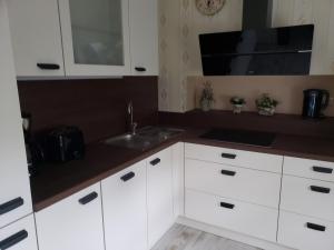a kitchen with white cabinets and a sink at Ferienwohnung Schlaubetal Müllrose 1 - Seenähe in Müllrose +3 photos