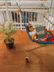 a woman sitting in a hammock with a laptop at Hostel Casa Maguey in Oaxaca City
