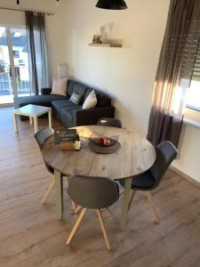 a living room with a wooden table and chairs at Zum Rheinblick in Lierschied