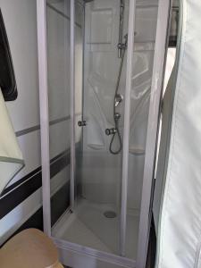 een douche met een glazen deur in een stacaravan bij Luxuswohnwagen Butterfisch am Kransburger See 420 in Kransburg