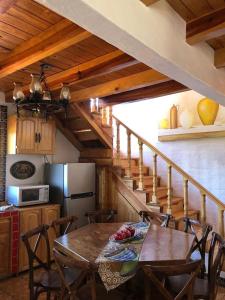 una cocina con una mesa de madera con sillas y una escalera en Cabaña Emiliano, en La Cofradía 14 fotos más