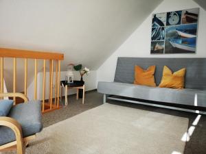 a living room with a blue couch with orange pillows at Harmonie in Prerow