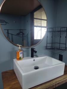 a bathroom with a white sink and a mirror at Arenal volcano apartment with panoramic view in El Castillo de La Fortuna