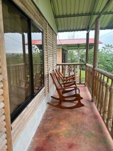 two rocking chairs sitting on the porch of a house at Cabañas venado 2 in Venado