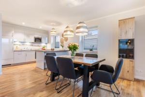 a kitchen and dining room with a table and chairs at Ferienhof Marquardt Bungalow 3 in Fehmarn