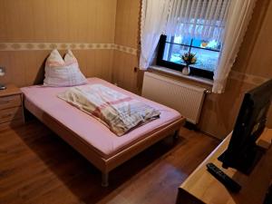 a small room with a bed and a window at Geräumige 5 Zimmerwohnung in Peitz