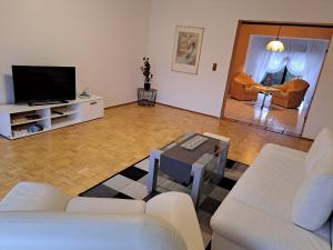 a living room with white furniture and a flat screen tv at Geräumige 5 Zimmerwohnung in Peitz