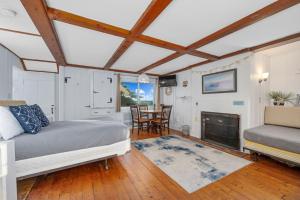 a bedroom with a bed and a table and chairs at Seaside Cottages - Cottage 26 - Williams Port in South Yarmouth