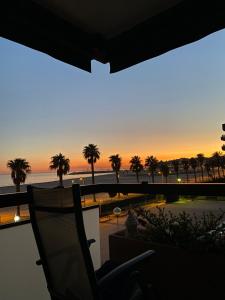 a chair on a balcony with a view of the ocean at Beach Front 2 Bedrooms Apartment in Torredembarra +10 photos