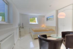a bedroom with a bed and a table and chairs at Abaluga 1A in Wenningstedt