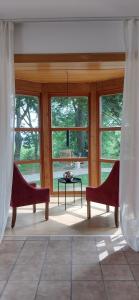 two chairs and a table in a room with windows at Fichtennest in Bingerbrück