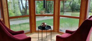 two chairs and a table in a room with windows at Fichtennest in Bingerbrück