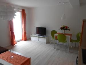 a living room with a television and a table and chairs at Ferienwohnung Haus Glückauf in Kölpinsee