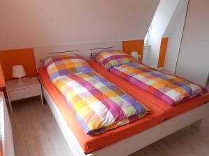 a bedroom with two beds with colorful pillows at Ferienwohnung Haus Glückauf in Kölpinsee