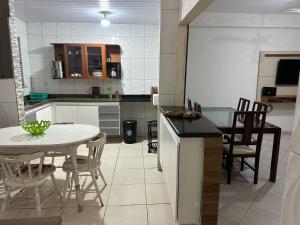 a kitchen and dining room with a table and chairs at Beach House Cabo Frio Hostel in Cabo Frio