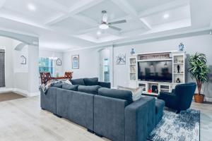 a living room with a blue couch and a tv at Spectacular NEW Home With Lots of parking Exit 284 in Palm Coast