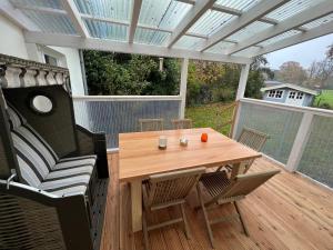 une terrasse avec une table et des chaises en bois. dans l'établissement Etzhorner Tied 2, à Oldenbourg