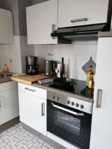 a kitchen with white cabinets and a stove top oven at Ferienhaus Gerdelmann in Haren
