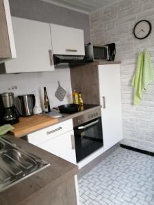 a kitchen with white cabinets and a stove top oven at Ferienhaus Gerdelmann in Haren