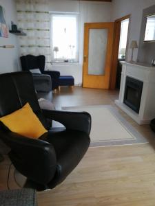 a living room with a black chair and a fireplace at Ferienhaus Gerdelmann in Haren +7 photos