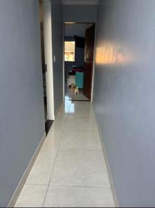 Un perro caminando por un pasillo en una casa. en Suíte família, en São Sebastião