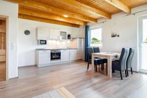 a kitchen and dining room with a table and chairs at Ferienwohnung Wattenmeer für 2 Personen am Badesee Tannenhausen in Aurich