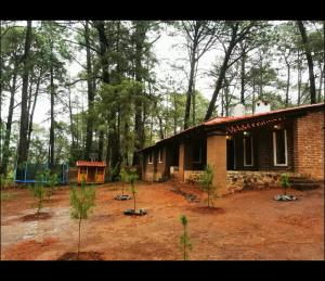 a small brick house in the middle of a forest at Cabañas Tapalpa la laja in Los Espinos +5 photos
