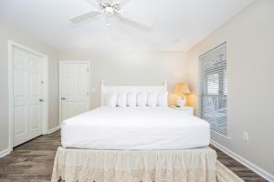 Un dormitorio blanco con una cama blanca y una ventana. en Bayside Bungalow 9531 home, en Gulf Highlands