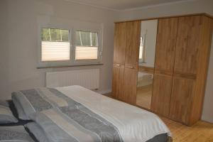 a bedroom with a bed and a large wooden cabinet at Ferienhof Thele Wohnung EG in Werlte