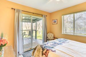 a bedroom with a bed and a sliding glass door at Fish, Hike & Relax: Rural Red Bluff Cottage in Red Bluff