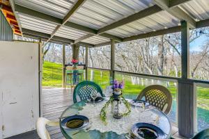 a table on a screened porch with a table and chairs at Fish, Hike & Relax: Rural Red Bluff Cottage in Red Bluff