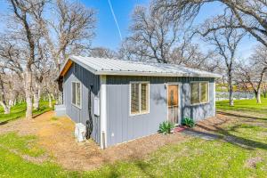 a small grey shed in a yard with trees at Fish, Hike & Relax: Rural Red Bluff Cottage in Red Bluff