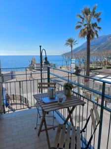 een tafel en stoelen op een balkon met uitzicht op het strand bij La Casa Lungo Il Mare in Maiori