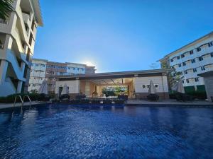a large swimming pool in front of a building at Our Happy Place - Cheer Residences in Marilao