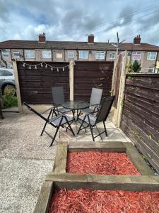 eine Terrasse mit Tisch und Stühlen und einem Zaun in der Unterkunft The Little Green Cosy Cottage in Bury + 10 Fotos