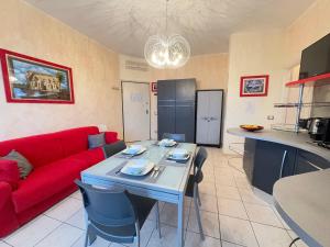 a living room with a red couch and a table at Private Garage, 300m from Sea in Alassio Centre in Alassio +15 photos