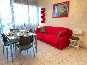 a living room with a red couch and a table at Private Garage, 300m from Sea in Alassio Centre in Alassio