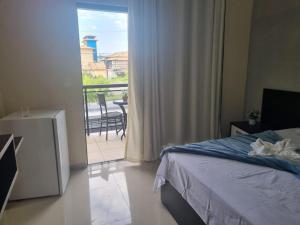 a bedroom with a bed and a view of a balcony at Casa alto padrão a 1 minuto da Praia in Rio das Ostras