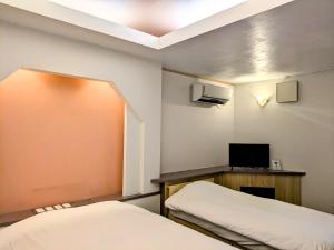 una stanza con due letti e una scrivania con una televisione di My Room a Takahata