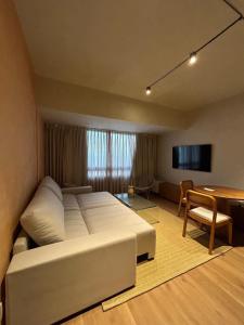 a bedroom with a large white bed and a table at Graça Apartment in Salvador