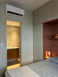a bedroom with a bed and a bathroom with a sink at Graça Apartment in Salvador